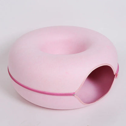 Pink zippered donut-shaped cat tunnel bed made of felt with an open entrance
